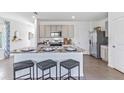 Modern kitchen featuring a large island with seating, stainless steel appliances, and sleek gray cabinetry at 35896 Sunflower Hill Dr, Zephyrhills, FL 33541