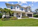 Charming two-story home featuring white siding, a well-manicured lawn, and a spacious two-car garage at 3905 W San Obispo St, Tampa, FL 33629