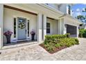 Inviting front porch adorned with seasonal flower pots, a stylish front door wreath, and a charming walkway at 3905 W San Obispo St, Tampa, FL 33629
