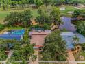 Aerial view of home with pool, golf course, and pond views, in a desirable community at 40 Pine Lake Dr, Oldsmar, FL 34677