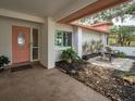 Inviting front entrance with a cozy sitting area, decorative plants, and a stylish door at 40 Pine Lake Dr, Oldsmar, FL 34677