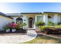 Welcoming front entrance with arched windows, decorative glass, and lush landscaping at 4822 Hamlets Grove Dr, Sarasota, FL 34235