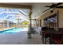 Covered outdoor patio with comfortable seating, ceiling fans, and a view of the pool at 4822 Hamlets Grove Dr, Sarasota, FL 34235
