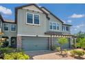 The neutral townhouse has a two car garage and stone accents on the facade at 4828 San Martino Dr, Wesley Chapel, FL 33543