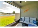 Relaxing screened patio with cozy seating overlooking the backyard and lake views at 4828 San Martino Dr, Wesley Chapel, FL 33543
