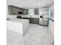 Modern kitchen boasts gray cabinets, stainless steel appliances, and an island with white quartz countertops at 547 16Th S Ave, St Petersburg, FL 33701