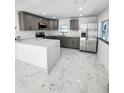 Modern kitchen boasts gray cabinets, stainless steel appliances, and an island with white quartz countertops at 547 16Th S Ave, St Petersburg, FL 33701