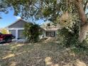 Charming single-story home with a well-manicured front yard and mature trees at 7421 Mulligan Ct, Port Richey, FL 34668