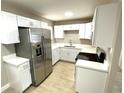 A bright kitchen featuring white cabinets, stainless steel appliances, and tile flooring at 8310 Croton Ave, Tampa, FL 33619