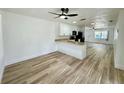 View of the light-filled living room showcasing the open layout, wood floors, and modern fixtures at 9230 Wood Dr, Hudson, FL 34667