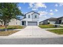 Two-story home boasts a modern design, two-car garage, and well-manicured lawn in a suburban neighborhood at 10013 Caraway Spice Ave, Riverview, FL 33578