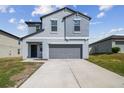 Two-story home boasts a modern design, two-car garage, and well-manicured lawn in a suburban neighborhood at 10013 Caraway Spice Ave, Riverview, FL 33578