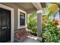 Welcoming porch with seating area framed by decorative plants and a view of the mature landscaping at 10148 Rose Petal Pl, Riverview, FL 33578