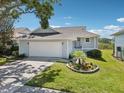 Well-maintained single-Gathering home with a charming front garden and two-car garage at 1015 S Pointe Alexis Dr, Tarpon Springs, FL 34689