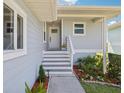 Inviting front porch with steps leading to the front door and lush landscaping at 1015 S Pointe Alexis Dr, Tarpon Springs, FL 34689