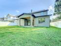 Large backyard with a covered patio, green lawn, and fenced perimeter at 1017 W Charter St, Tampa, FL 33602