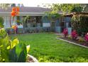 Well-manicured front yard with colorful flowerbeds, lush green lawn, and a charming home exterior at 12021 144Th St, Largo, FL 33774