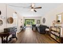 Inviting living room featuring wood-look flooring, ceiling fan, neutral paint and balcony access with views of a garden at 1250 S Pinellas Ave # 405, Tarpon Springs, FL 34689