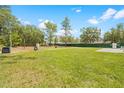 Spacious backyard with lush green grass, trees and partial fence, great for outdoor activities at 15062 Hummingbird Rd, Weeki Wachee, FL 34614