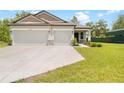 Exterior of house with a 3-car garage showcasing a spacious driveway and manicured front yard at 15062 Hummingbird Rd, Weeki Wachee, FL 34614