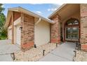 Exterior of home with arched entrance, stone details and concrete walkway at 1831 Stable Trl, Palm Harbor, FL 34685