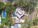 Aerial view of property showing house, pool, tennis court, and mature trees at 2710 N Dundee St, Tampa, FL 33629