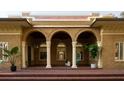 Inviting front porch with brick flooring, white pillars, and hanging plants at 2710 N Dundee St, Tampa, FL 33629