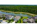 An aerial view of a beautiful home in a community with a lake and lush green landscaping in the backyard at 2826 Riders Pass, Odessa, FL 33556
