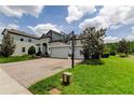 Charming two-story home with a three car garage, beautiful landscaping, and a basketball hoop on the driveway at 2826 Riders Pass, Odessa, FL 33556