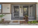 Inviting screened entry showcasing a welcome sign, lush landscaping, and a glimpse of the interior at 2945 Grovewood Blvd # D, Palm Harbor, FL 34683