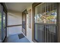 Charming front porch with welcome sign, screen door, and large window letting in natural light at 2945 Grovewood Blvd # D, Palm Harbor, FL 34683