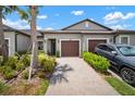 Well-maintained townhome with a brick driveway, two-car garage, and manicured landscaping at 31354 Cabana Rye Ave, San Antonio, FL 33576