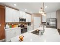 Beautiful kitchen with white cabinets, granite countertops, stainless steel appliances, and modern lighting fixtures at 31354 Cabana Rye Ave, San Antonio, FL 33576