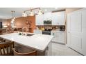 Bright kitchen featuring a large island with quartz countertops, stainless steel appliances, and white cabinets at 31354 Cabana Rye Ave, San Antonio, FL 33576