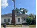 Charming single-story home with a classic white exterior, brick chimney, and welcoming front entrance at 3210 W North B St, Tampa, FL 33609