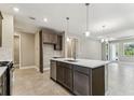 Modern kitchen with stainless appliances, island, and a seamless transition to the dining area at 3737 Nandina Cir, Sun City Center, FL 33573