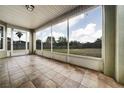 Enclosed patio with large screened windows overlooking the backyard and tiled flooring at 37437 Laurel Hammock Dr, Zephyrhills, FL 33541