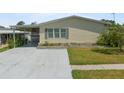Inviting single-story home featuring neutral siding, a carport, and a meticulously kept front lawn at 37639 Newport Dr, Zephyrhills, FL 33542