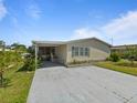 Attractive single-story home boasting a covered carport, a screened porch, and blossoming landscaping at 37639 Newport Dr, Zephyrhills, FL 33542