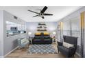 Inviting living room featuring modern ceiling fan, sleek black sofa, and view of the adjacent kitchen area at 404 Hammock Pine Blvd # 404, Clearwater, FL 33761