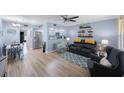 Open concept living room with wood floors, stylish furniture, and open access to the bright kitchen at 404 Hammock Pine Blvd # 404, Clearwater, FL 33761