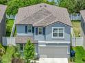 Two-story home featuring light blue siding, a gray roof, attached two car garage, and a well-maintained lawn at 413 Royal Empress Dr, Ruskin, FL 33570