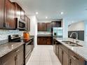 Modern kitchen features granite countertops, stainless steel appliances, and dark wood cabinetry at 413 Royal Empress Dr, Ruskin, FL 33570