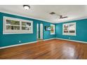 Bright living room showcasing wood floors, white trim, ceiling fan, and large windows with shutter-style blinds at 4330 7Th N Ave, St Petersburg, FL 33713