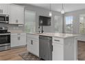 Modern kitchen with stainless steel appliances, island with sink, and hardwood floors at 444 49Th N St, St Petersburg, FL 33710