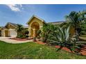 Home featuring mature landscaping and a lush green lawn at 4452 Bardsdale Dr, Palm Harbor, FL 34685
