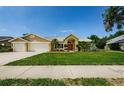 Charming home with a well-maintained lawn and a three car garage at 4452 Bardsdale Dr, Palm Harbor, FL 34685