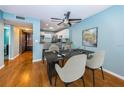 Stylish dining area with a modern table, chairs, and a ceiling fan, adjacent to the kitchen at 4805 Alt 19 # 421, Palm Harbor, FL 34683