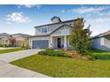 Charming two-story home features a well-manicured lawn, attached garage, and inviting entryway at 4808 Jackson Club Loop, Tampa, FL 33624