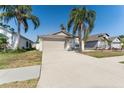 Well-maintained home showcasing a two-car garage and driveway with tropical landscaping at 518 Royal Ridge St, Valrico, FL 33594